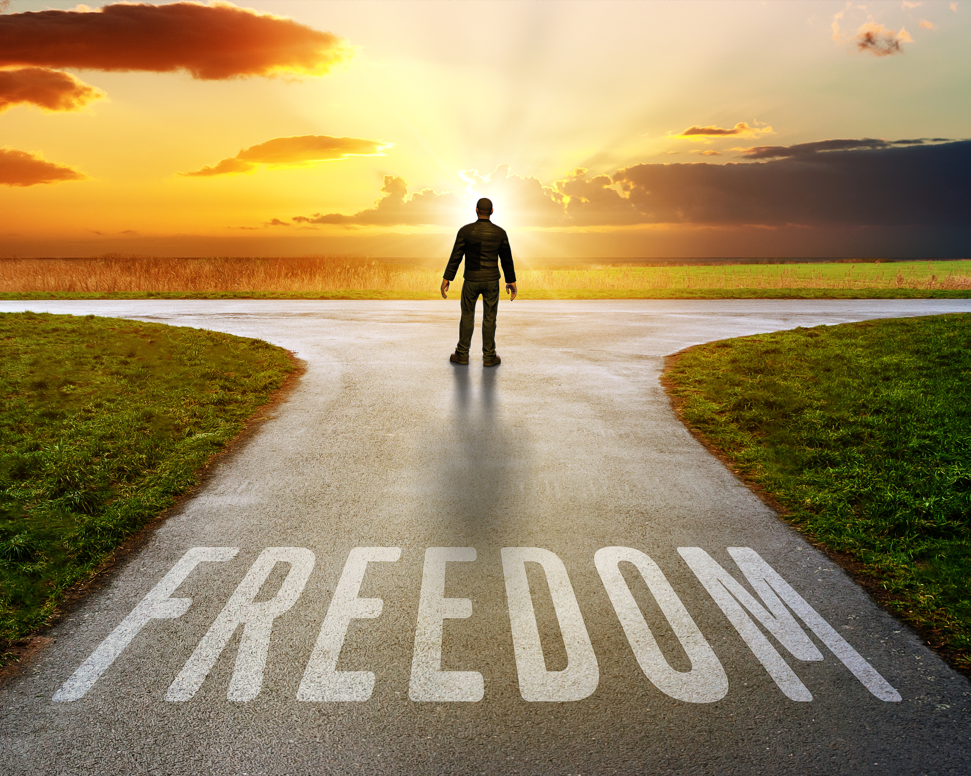 Person standing with arms raised on mountain peak, symbolizing freedom and achievement