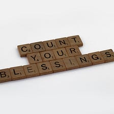 An image of scrabble blocks speling out the words ‘count your blessings’.