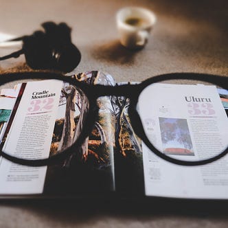 Looking through glasses at an open magazine