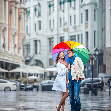 Couple in love standing under an umbrella in the rain