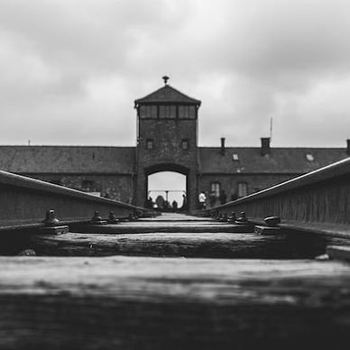 a black and white photo of a concentration camp entrance.
