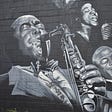 Black and white photo of a mural on the wall of Harlem Renaissance musicians.