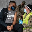 A man speaks with a member of the National Guard after receiving a coronavirus vaccine in the parking lot of Six Flags on February 6, 2021 in Bowie, Maryland.