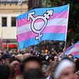 Transgender pride flag waving at a parade.