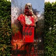 A photo of a vandalized statue of King Leopold II in Belgium. It is covered in red paint and graffiti.