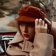 Photo of Taylor Swift in beige coat with red lipstick