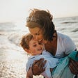 Woman holding her son on the beach living the good life