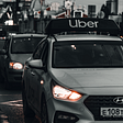 An Uber driver’s car with Uber signage on its roof