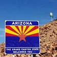 A “Welcome to Arizona sign” at the state border. This article is about whether tax changes cause the wealthy to flee. Funny?