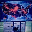 Laboratory with pandemic spread on a U.S. map on a large screen. Photo by janiecbros/Getty Images