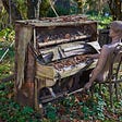 Old piano in a woods with half of a mannequin sitting at it