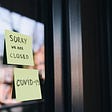 Sorry we are closed. COVID-19. Posted on a window written on sticky notes.