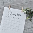 A calendar reading “January 2022” sits on a table.