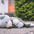 Torn teddy bear lying on the ground