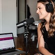 Person sitting in front of a microphone and recording a podcast.