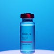 Covid-19 vaccine bottle on a blue background