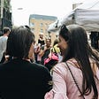 Two women walking in a market place