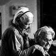 Two old ladies, friends helping each other in their old age.