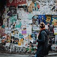 A passerby looking at this huge wall filled with posted bills as if interested in something there as an example of what it would look like if some reader-passerby came upon a good long form comment that should probably earn.