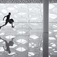 This is an image of a man carrying a brief case and running over the shadows of 6-figure objects. likely a glass wall