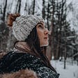 woman in winter with hat on looking to the future and the sky