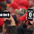 Trump supporters hold up their phones with messages referring to the QAnon conspiracy theory at a campaign rally.