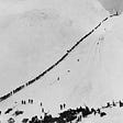 A bird’s eye view of hundreds of prospectors climbing the Chilkoot Pass in winter