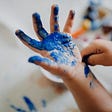 Photo of a kids hand with blue paint