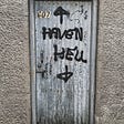 A creepy door has heaven (spelled incorrectly) written on it with an arrow pointing up and  hell pointing down.