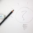 pencil and eraser, someone has drawn a lightbulb with a question mark inside
