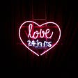 neon sign of heart with words inside: love 24 hrs