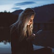Cross addiction: Image of woman looking intently at her phone