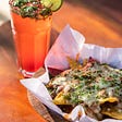 A plate of nachos and a beverage