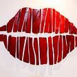 Photo of painted red lips with white background.