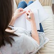 A girl is writing on a notebook.