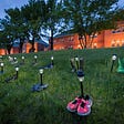 Pairs of children’s shoes lit across the grass outside of an old residential school in Kamloops, BC, the site of a mass grave of Indigenous children.