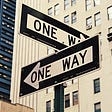 Two sign boards titled “One Way” crossing each other