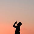 A praying man at sunset