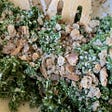 A green kale salad with bits of bread and a spatula sticking out of it.