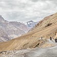 Three motorcycles traveling on an unpaved mountain road