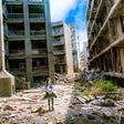 A young girl walks between two blocks of derelict buildings in a war-torn zone