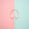 Pink headphones on a pink and blue background