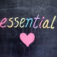 A black chalkboard with rainbow chalk used to write out the word ‘essential’ followed by a pink heart as a mneumonic for ‘essential love’ or something essential as in my idea that to be is to also continually break your own stereotypes.