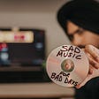 An anxious person displays a “sad music” CD