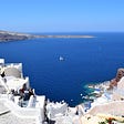 White building and blue waters of sunny Greece.