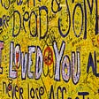 Writing on a yellow wall with “I loved you” in the center.
