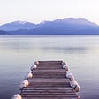 Calm lake mountain background wooden pier