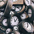 A pile of antique clocks, representing time. Photo by Jon Tyson on Unsplash