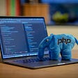 Computer with stuffed elephant on top