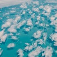 puffy clouds over a bright blue sea viewed from above